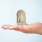 The RIP decorated headstone from the Bumbu Toys Gravestones Set. The headstone is placed on an adult's hand.