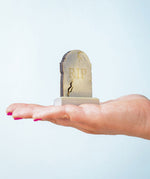 The RIP decorated headstone from the Bumbu Toys Gravestones Set. The headstone is placed on an adult's hand.