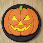 The Bumbu Halloween Pumpkin Round Wooden Puzzle pictured on it's black coloured base frame. The puzzle is on a wooden surface.