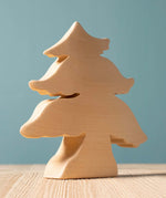 A Bumbu large paint your own wooden toy figure placed on a wooden surface. This paint your own figure is part of a large collection of paint your own wooden figures available at Babipur.