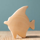 A Bumbu Moorish Idol Fish wooden figure placed on a wooden surface. This figure is part of a larger range of wooden paint your own toys. 
