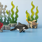 A Bumbu Toys Baby Orca placed in the centre of a small world play scene.