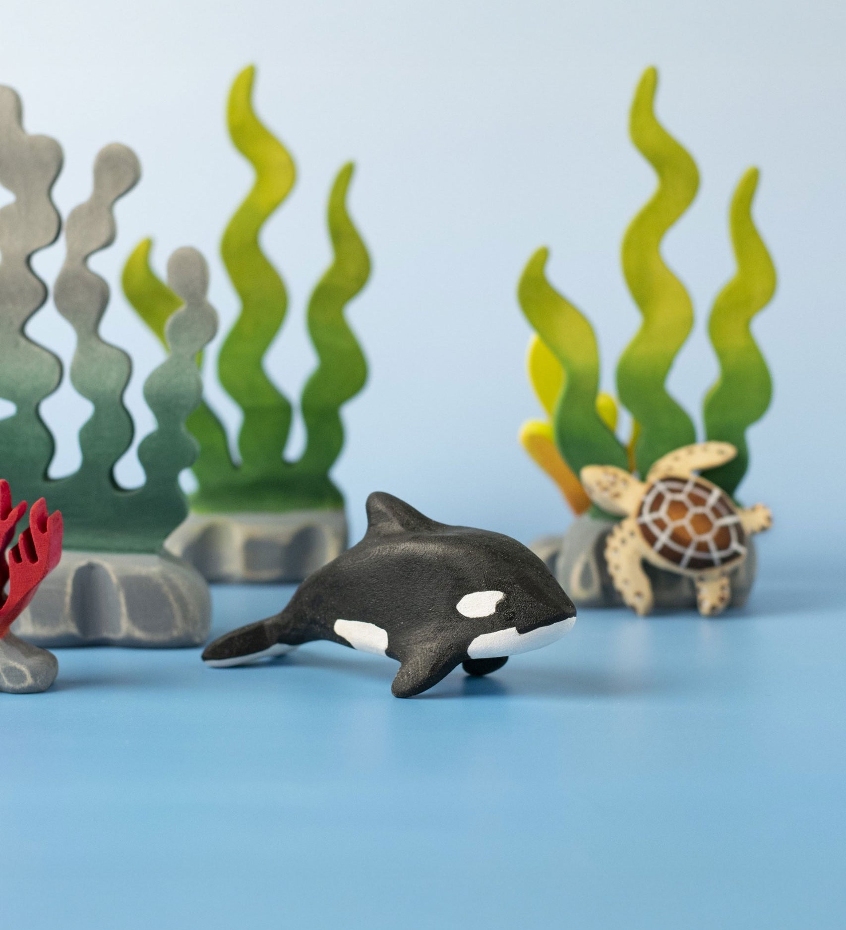A Bumbu Toys Baby Orca placed in the centre of a small world play scene.