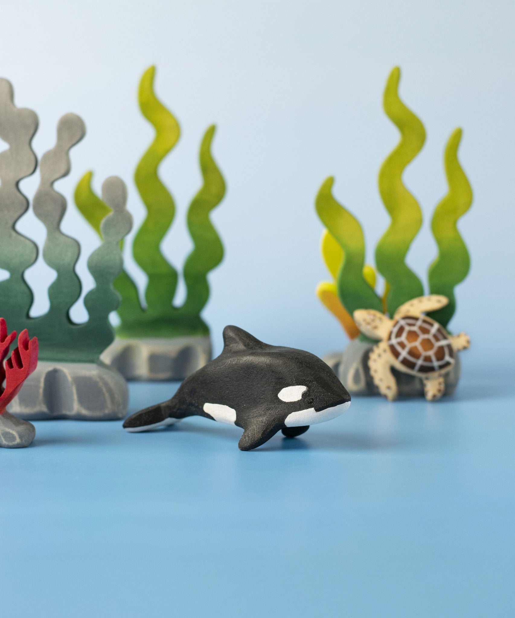 A Bumbu Toys Baby Orca placed in the centre of a small world play scene.