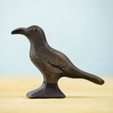 Bumbu Toys Raven wooden figure. The figure is on a wooden surface. 