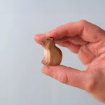 Bumbu Toys Wooden Sitting Baby Capybara, being held in an adult's hand.