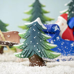 A Bumbu Small Snowy Fir Tree placed in the centre of a festive small world play scene. 