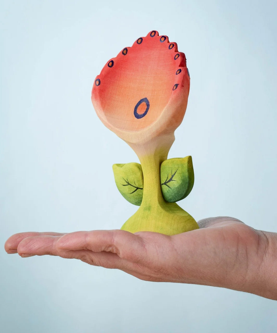 The Bumbu Toys Perla Spring Flower shown in and adult's hand.
