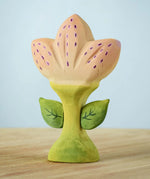 The Bumbu Toys Zia Spring Flower has a pinky peach coloured flower with purple detailing and a green coloured stem. 