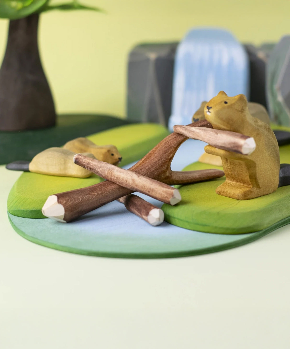 A Bumbu Toys Black Poplar Branch seen in a small world play set up with the Bumbu beavers, lake and waterfall in the background. 