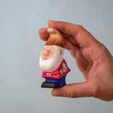 The Bumbu Toys Whittle Dwarf shown in an adult's hand. 