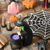 A Bumbu wooden witch standing next to a wooden cauldron in a halloween  small world play scene. These expertly hand crafted items are part of a large range of wooden toys available here at Babipur. 