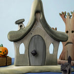 Bumbu Toys Witches house placed in the centre of a Halloween themed small world play set up. 