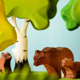 Play scene showing Bumbu toys handcrafted wooden brown standing bears and trees in the background