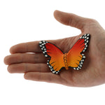Bumbu Wooden Butterfly Figure pictured in an adult's hand on a plain background 