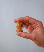 The Bumbu Toys wooden baby rabbit, in a curious upright position, held in a hand for size reference