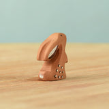 A back view of The Bumbu Toys wooden baby rabbit, in a curious upright position.