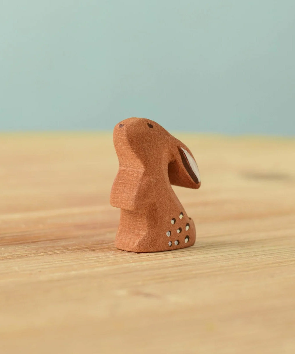 The Bumbu Toys wooden baby rabbit, in a curious upright position.