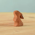 The Bumbu Toys wooden baby rabbit, in a curious upright position.