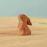 The Bumbu Toys wooden baby rabbit, in a curious upright position.