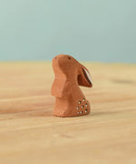 The Bumbu Toys wooden baby rabbit, in a curious upright position.