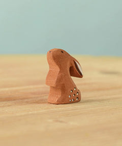 The Bumbu Toys wooden baby rabbit, in a curious upright position.