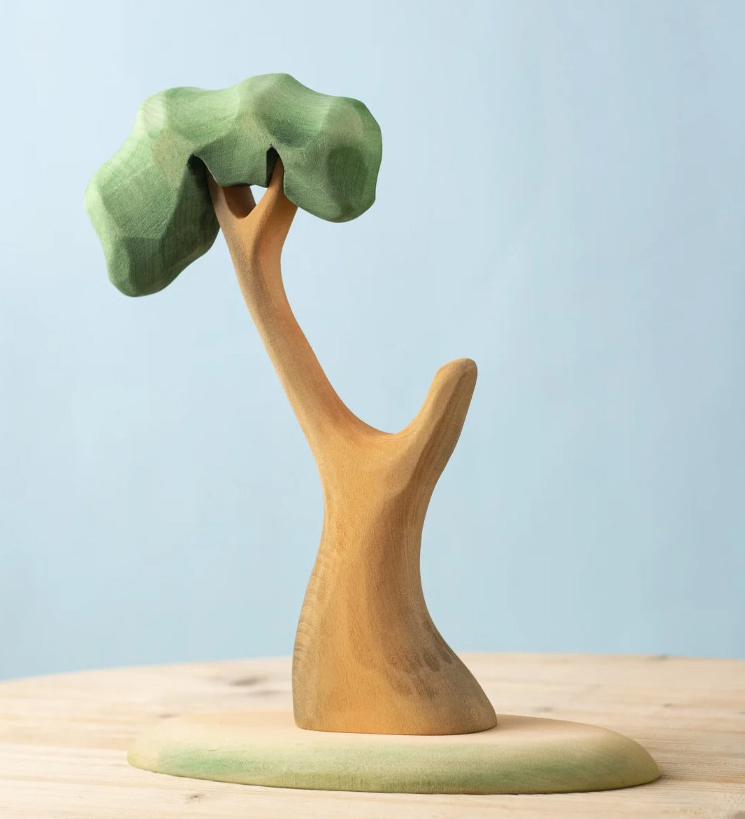 A Bumbu Toys Eucalyptus Tree placed on a wooden surface. These handmade wooden figures make wonderful scenery for small world play that pair well with our collection of wooden toy figures here at Babipur. 
