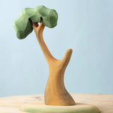 A Bumbu Toys Eucalyptus Tree placed on a wooden surface. These handmade wooden figures make wonderful scenery for small world play that pair well with our collection of wooden toy figures here at Babipur. 