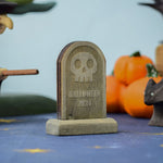 The skull decorated headstone from the Bumbu Toys Gravestones Set. The headstone is pictured in a Halloween themed play scene. 