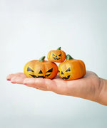 The Bumbu Toys Halloween Pumpkins Set shown on an adult's hand. 