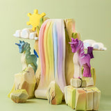 The Bumbu Toys Rainbow waterfall and Rainbow Rocks shown in a small world play scene alongside Bumbu unicorns. 