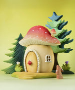 The Bumbu toadstool house shown in a small world play scene alongside Bumby trees, flowers and a rabbit.