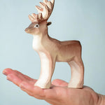 A Bumbu Toys Reindeer placed in the palm of an adult's hand.