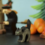 Bumbu Toys Scared Black Cat figure. The cat's tail is stood up and the cat has green eyes. The cat is placed at the front of a Halloween themed play scene. 