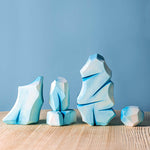 penguins and swans laid out on a light blue background in front of some Bumbu Waldorf icy rocks and white Maple tree toys