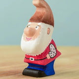 The Bumbu Toys Whittle Dwarf has a red coloured top, blue trousers, a brown hat and a white beard.