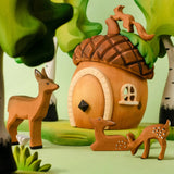 A playscene showing a Bumbu toys acorn house, deer and squirrel figures and trees in the background.