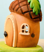 Side view of the Bumbu toys handcrafted wooden acorn house showing cut out window detail