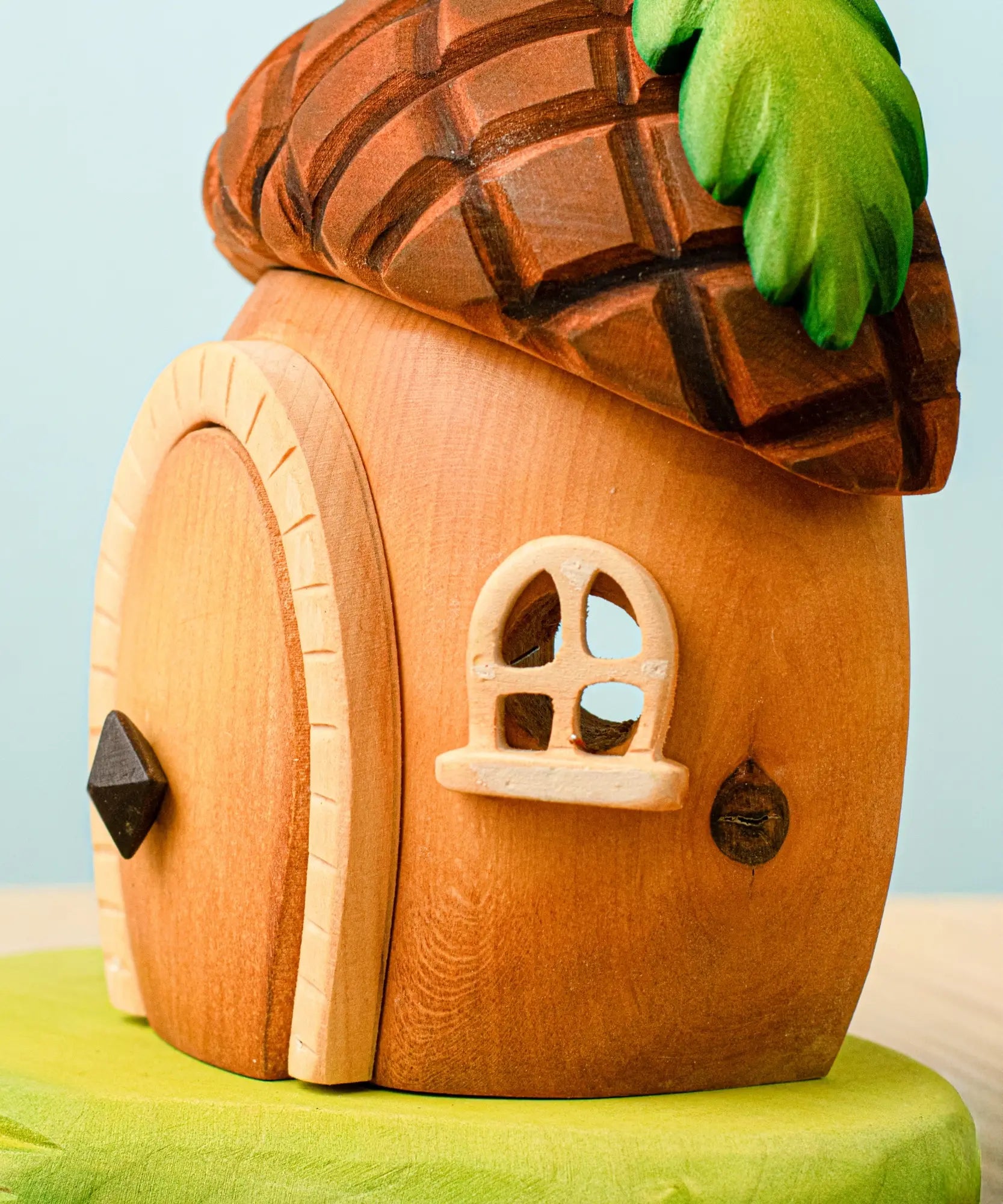 Side view of the Bumbu toys handcrafted wooden acorn house showing cut out window detail