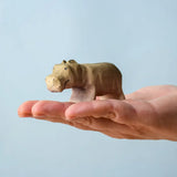 Bumbu toys handcrafted wooden grey standing baby hippo figure in a hand showing scale
