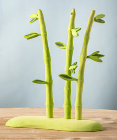 A Bumbu wooden bamboo set on a green base, features detachable leaves.
