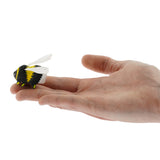 The Bumbu Wooden Bumblebee Figure pictured on an adult's hand
