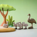 A play scene featuring the Bumbu wooden female emu standing next to emu chicks and a sitting emu chick