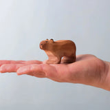 Bumbu Toys Wooden Capybara, being held in an adult's hand.