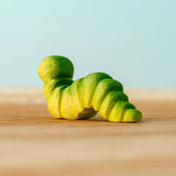 Back of a Bumbu handcrafted wooden green caterpillar figure 