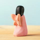 Back of the Bumbu handcrafted wooden cherry fairy figure with painted black hair and wings