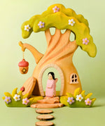 Bumbu handcrafted wooden cherry fairy figure standing in the fairy treehouse doorway