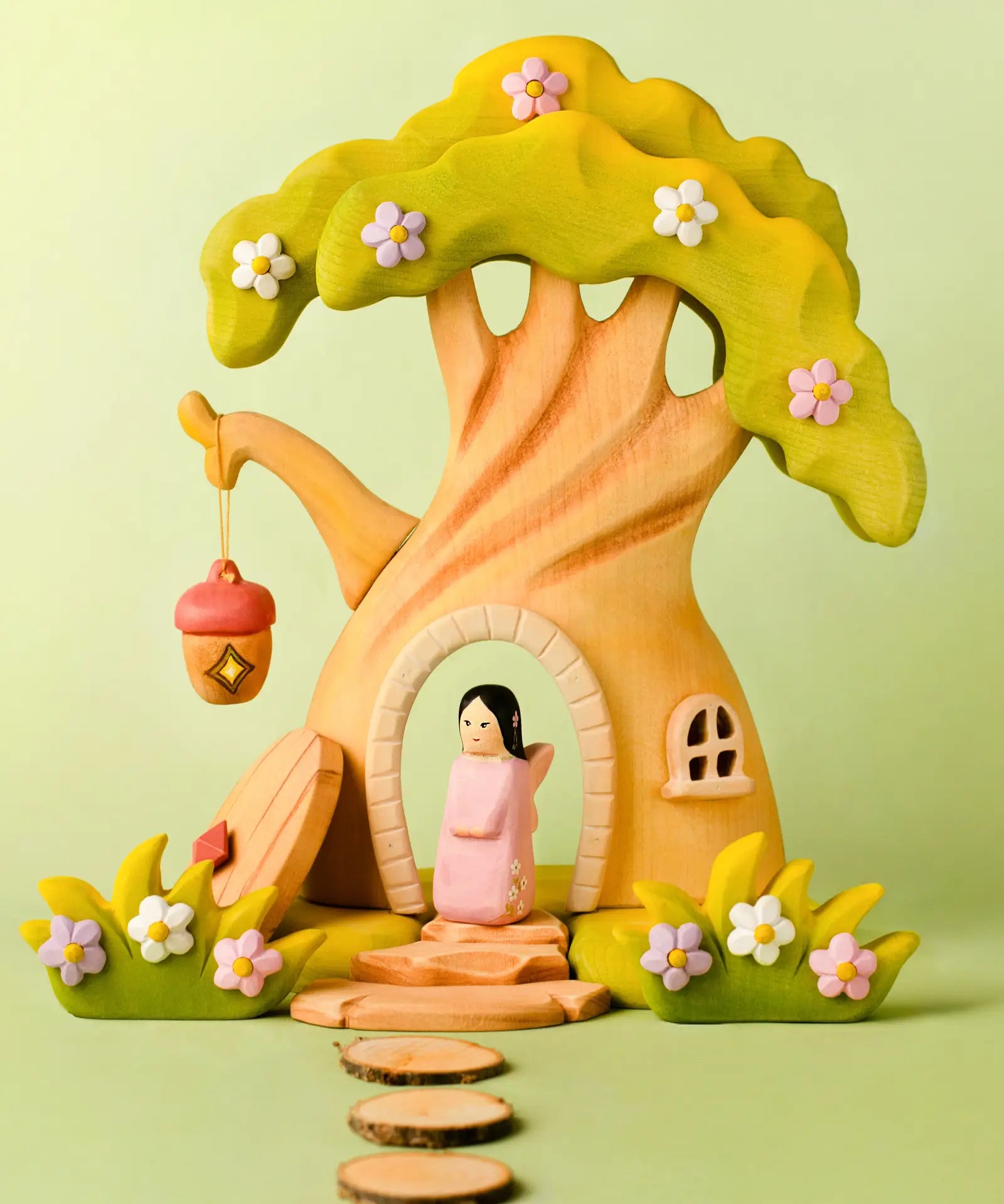 Bumbu handcrafted wooden cherry fairy figure standing in the fairy treehouse doorway