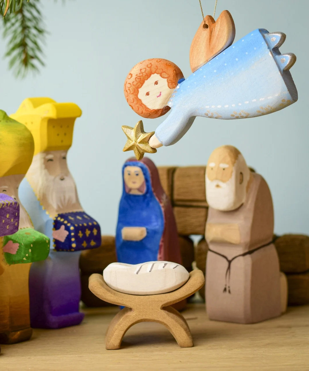 A Bumbu Christmas angel hanging above a festive small world play scene. 