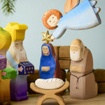 A Bumbu Christmas angel hanging above a festive small world play scene. 